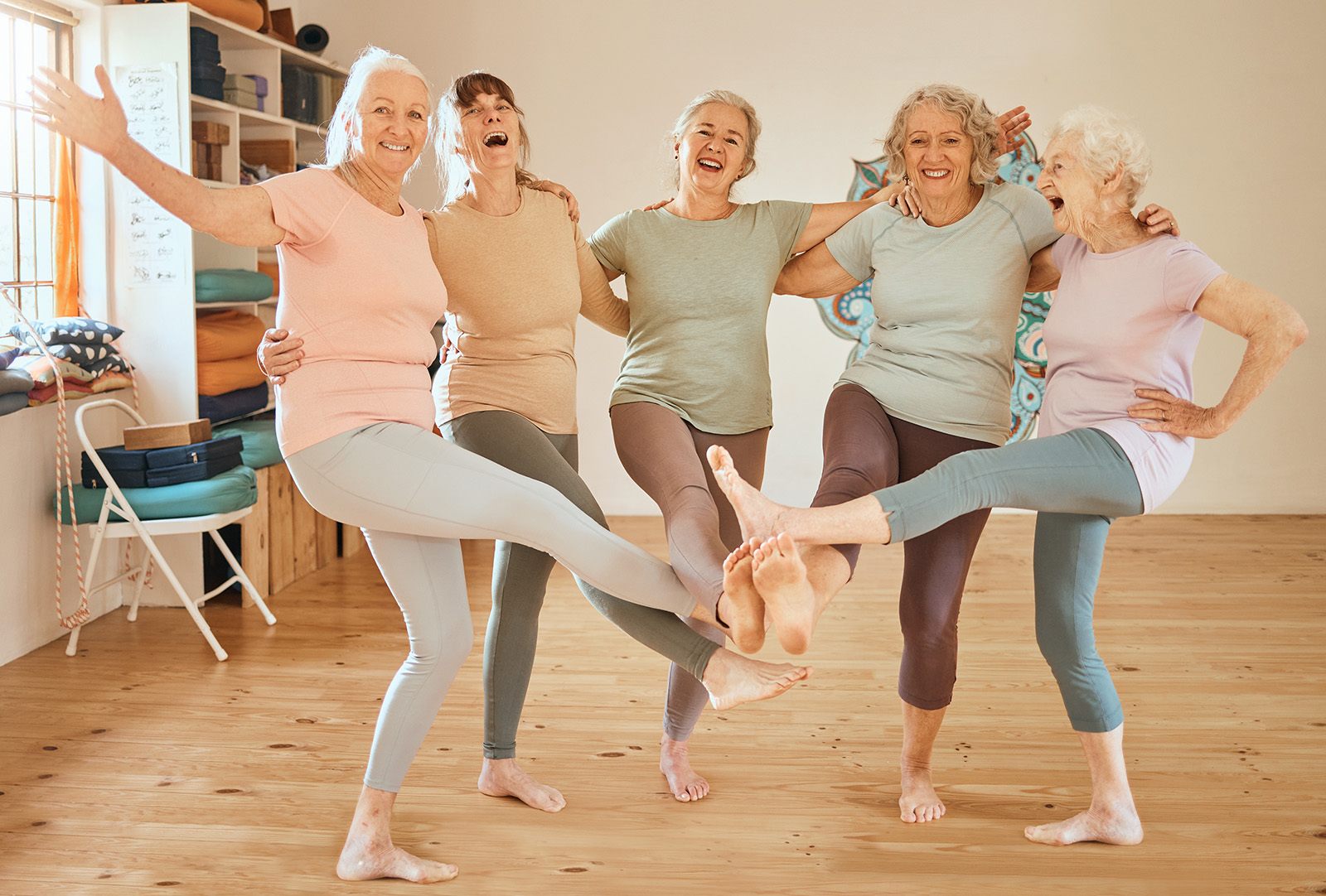 Vier Frauen lachen und tanzen in einem hellen Raum